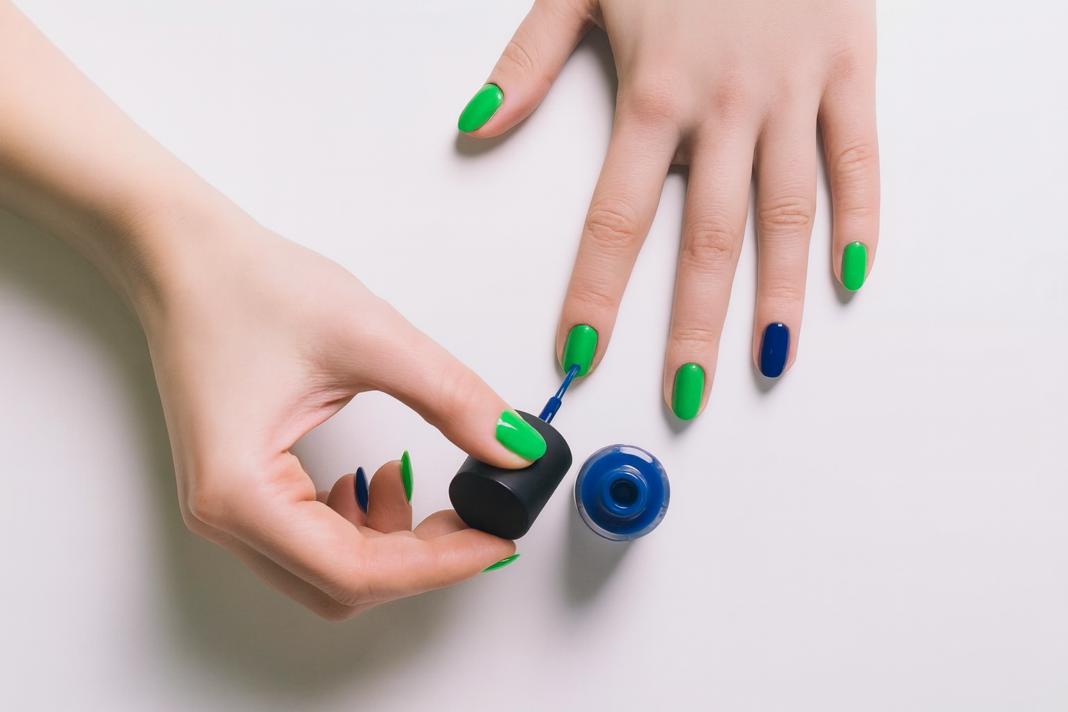 Fingernails polished in green and blue